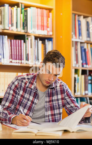 Stattliche fokussiert student Notizen in der Bibliothek Stockfoto