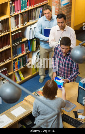 Hohe Betrachtungswinkel der Reife Studenten am Zähler in der Hochschule Bibliothek Stockfoto