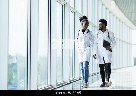 Zwei Ärzte oder Krankenschwestern mit Zwischenablage entlang Krankenhaus Flur Stockfoto