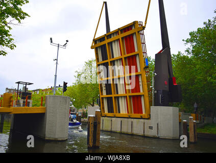 Öffnen der Brücke zu Boat Pass unterhalb in einem schmalen Kanal, Amsterdam, Niederlande. Stockfoto