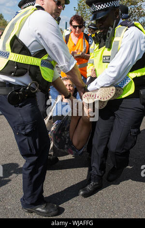 London, Großbritannien. 3. September, 2019. Polizisten verhaften Quäker Sperrung einer der beiden wichtigsten Zufahrtsstraßen zu ExCel London am zweiten Tag der Woche - lange Proteste gegen DSEI, der größten Waffen der Welt. Proteste wurden rund um Glauben und Gebet und Gläubigen, die aus mehreren Religionen einschließlich der Quäker in Solidarität gegen den Waffenhandel. Credit: Mark Kerrison/Alamy leben Nachrichten Stockfoto