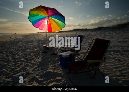 Sonnenschirm und Stühle in den Sand neben der Golf von Mexiko auf dem Fort Morgan Halbinsel im tiefen Süden Alabama, USA. Stockfoto