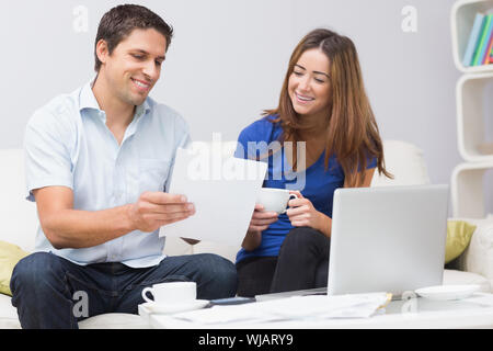 Paar Zahlen ihre Rechnungen online zu Hause Stockfoto