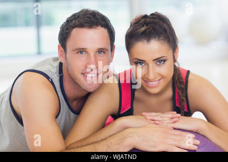 Junge Frau und Mann mit abgeschnittenen Fitness-Ball in einem Fitnessstudio Stockfoto