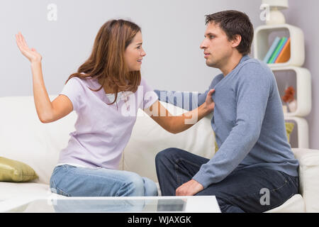 Junge Frau zu Mann im Wohnzimmer zu Hause schlagen Stockfoto