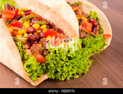 Selektiven Fokus auf dem vorderen Taco Sandwich auf hölzernen Hintergrund Stockfoto