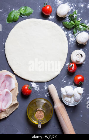 Teig Grundlage mit Ketchup und Zutaten für Pizza, auf dem Tisch Stockfoto