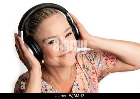 Frau mittleren Alters in 40 s gerne Musik auf kabellose Bluetooth® Kopfhörer Stockfoto