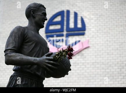 Eine Statue des ehemaligen Bolton Wanderers player Nat Lofthouse außerhalb der Erde vor der EFL-Trophäe nördlichen Abschnitt Gruppe F Match an der Universität Bolton Stadion. Stockfoto