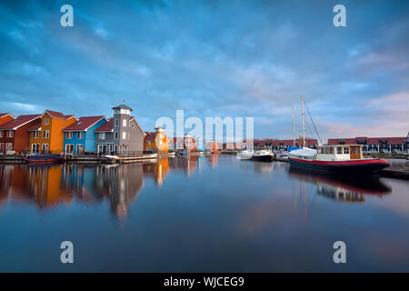 Sonnenaufgang über dem farbenfrohen Gebäuden und Boote Reitdiephaven, Groningen, Niederlande Stockfoto