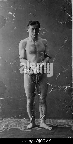 Harry Houdini, full-length Portrait, stehend, nach vorne, in Ketten Stockfoto