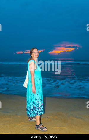 Frau gegen Sonnenuntergang über einem Strand von Wadduwa in der westlichen Provinz Sri Lanka, Asien Stockfoto