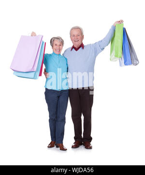 Portrait Of Happy Senior Couple Holding Shopping Bags Stockfoto