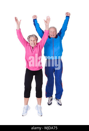 Porträt von älteres paar springen In Freude Over White Background Stockfoto