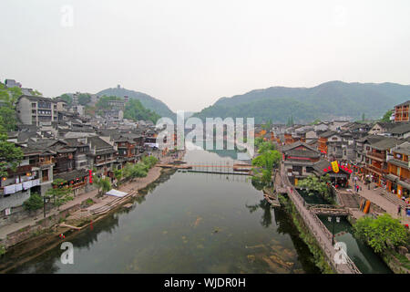 FENGHUANG - Mai 12: Holz- Boot- und Holzhäuser auf tuojiang Fluss in der alten Stadt fenghuang am 12. Mai 2011 in Fenghuang, China. Stockfoto