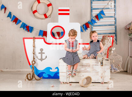 Zwei kleine Mädchen spielen mit Muscheln, Meer Thema. Stockfoto