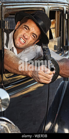 1920er Jahre Vintage Gangster Schießen Pistole vom Autofenster Stockfoto