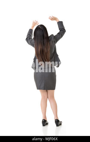 Jungen asiatischen Business woman Hold up etwas über ihrem Kopf. Ansicht von hinten. Volle Länge portair. Auf den weißen Hintergrund isoliert. Stockfoto