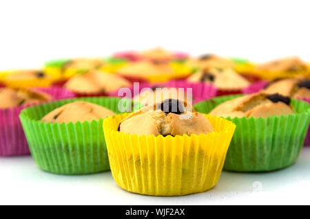 Nahaufnahme von Cupcakes in bunten Papieren auf weißem Hintergrund Stockfoto