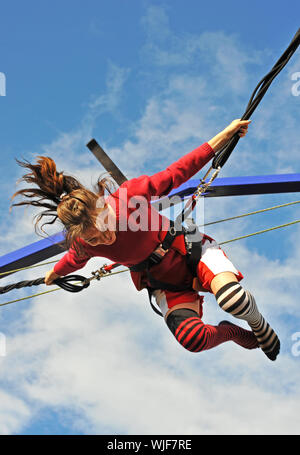 Junger Teenager springen auf dem Trampolin (Bungee-jumping). Stockfoto