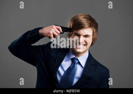 Betonte Geschäftsmann geben einen Schuss auf seinen eigenen Kopf Stockfoto