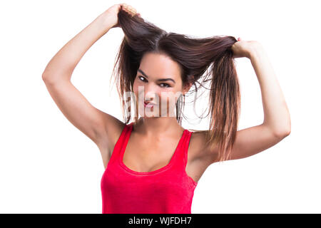 Schöne junge Frau packte ihre eigenen Haare, isoliert auf weißem Hintergrund Stockfoto