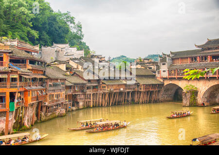 Fenghuang, China. September 13, 2015. Touristische Boot unterwegs Enmasse auf der Tuo Jiang River in Fenghuang antiken Stadt in der Dämmerung in der Provinz Hunan in China Stockfoto