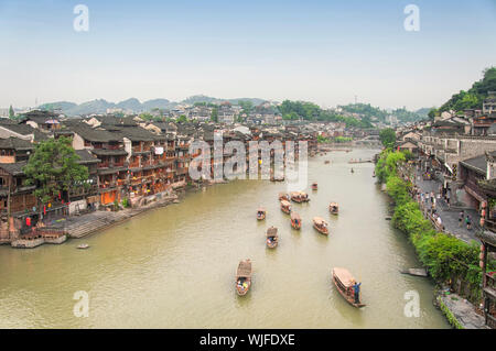 Fenghuang, China. September 13, 2015. Touristische Boot unterwegs Enmasse auf der Tuo Jiang River in Fenghuang antiken Stadt in der Dämmerung in der Provinz Hunan in China Stockfoto