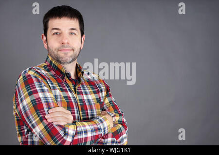 Sicher, vertrauenswürdig, freundlich Mann mittleren Alters, normaler Typ auf grau Stockfoto