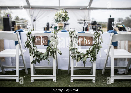 Hochzeit Tabelle unter Zelt, mit Herrn und Frau Anzeichen auf den Stühlen Stockfoto