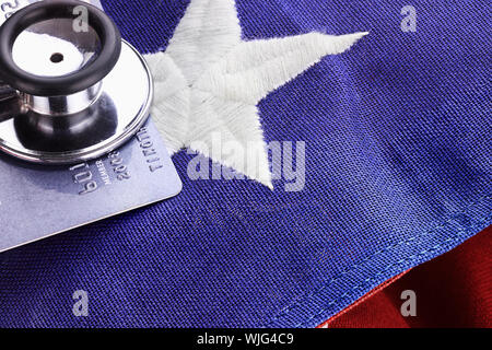 Stethoskop über amerikanische Flagge und Kreditkarte. Stockfoto