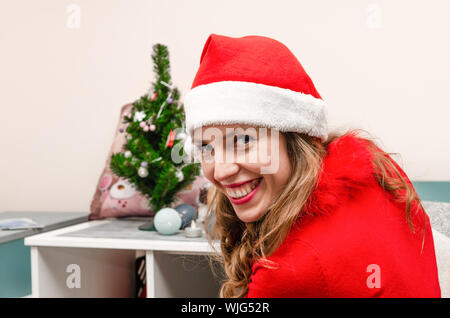 Portrait Of Happy hübsche rothaarige Mädchen in Weihnachten hat Lachen und Kamera gekleidet Stockfoto