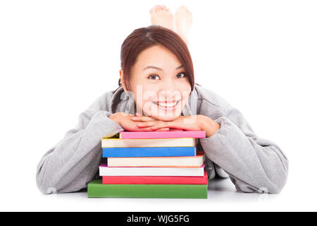 asiatische junge Studentin auf gestapelten Bücher liegen Stockfoto