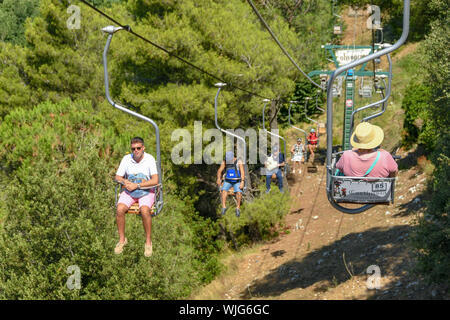 ANACAPRI, Capri, Italien - AUGUST 2019: Besucher auf einem Sessellift fahren nach oben und unten auf den Gipfel des Monte Solaro oben Anacapri Stockfoto
