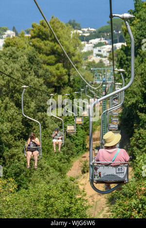 ANACAPRI, Capri, Italien - AUGUST 2019: Besucher auf einem Sessellift fahren nach oben und unten auf den Gipfel des Monte Solaro oben Anacapri Stockfoto