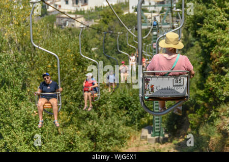 ANACAPRI, Capri, Italien - AUGUST 2019: Besucher auf einem Sessellift fahren nach oben und unten auf den Gipfel des Monte Solaro oben Anacapri Stockfoto