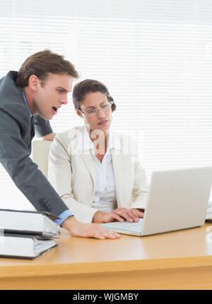 Intelligent business Paar mit Laptop im Büro Schreibtisch gekleidet konzentriert Stockfoto