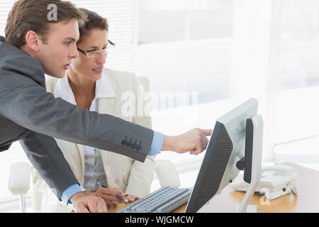 Seitenansicht des Intelligent business Paar mit Computer im Büro Schreibtisch gekleidet Stockfoto