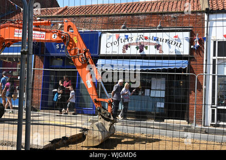 Ein Loch in der Sheringham High Street vor dem Crofters Restaurant. Stockfoto