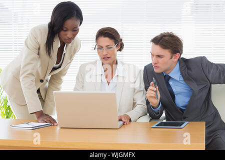 Konzentrierte sich Kollegen mit Laptop in einer Besprechung im Büro Schreibtisch Stockfoto