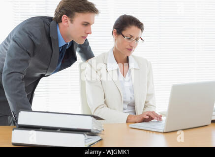 Intelligent business Paar mit Laptop im Büro Schreibtisch gekleidet konzentriert Stockfoto