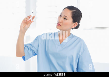Ernst Ärztin Holding eine Injektion in den hellen Krankenhaus Stockfoto