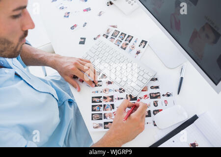 Hohe Betrachtungswinkel eines männlichen Photo Editor bei der Arbeit im Büro Stockfoto