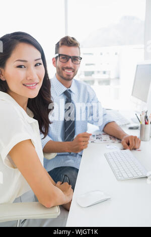 Seitenansicht des beiläufigen Foto Editoren Arbeiten am Computer in einem hellen Büro Stockfoto