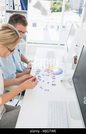 Seitenansicht des beiläufigen Foto Editoren arbeiten an Computern in einem hellen Büro Stockfoto