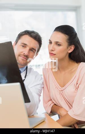 Männlicher Arzt erklären, x-ray Bericht für einen Patienten in medizinischen Büro Stockfoto