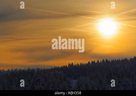 Erstaunlich Sonnenstrahlen in einem goldenen Himmel über Wald im Winter. Nationalparks Harz, Deutschland Stockfoto