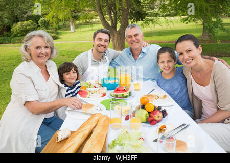 Portrait der erweiterten Familie Speisen am Tisch im Freien Stockfoto