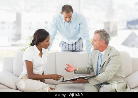 Verkäufer mit Kunden, in denen der Vertrag in das Amt zu unterzeichnen Stockfoto