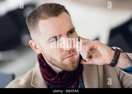 Junge schweren Mann mit Schal und Mantel Gespräch am Handy close-up Stockfoto